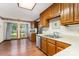 Bright kitchen with wooden cabinets, laminate counters, stainless steel dishwasher, and wood-look flooring at 614 W Peeler St, Salisbury, NC 28146