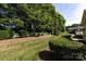 Beautiful backyard with lush greenery, mature trees, and a white fence enclosing the property at 6811 Ledgestone Pl, Charlotte, NC 28227