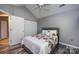 Bedroom featuring a ceiling fan, double closet, and grey hardwood floors at 6811 Ledgestone Pl, Charlotte, NC 28227