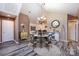 Elegant dining room with chandelier, gray plank flooring, and access to kitchen and living areas at 6811 Ledgestone Pl, Charlotte, NC 28227