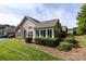 Attractive home exterior featuring stone accents, a well-maintained lawn, and manicured landscaping at 6811 Ledgestone Pl, Charlotte, NC 28227