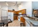 Traditional eat-in kitchen featuring wood cabinets, white appliances, tile backsplash and flooring, and a ceiling fan at 6811 Ledgestone Pl, Charlotte, NC 28227