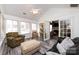 Bright living room with vaulted ceiling, gray plank flooring, and a view into an adjacent room at 6811 Ledgestone Pl, Charlotte, NC 28227