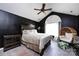 Stylish main bedroom with a window lounge area, dark walls, hardwood floors, and a ceiling fan at 6811 Ledgestone Pl, Charlotte, NC 28227
