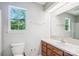 Bright bathroom features a window and a vanity with wood cabinets at 7217 Rena Mae Ln, Charlotte, NC 28227