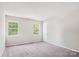 This bedroom has neutral walls, carpet, and natural light from two windows at 7217 Rena Mae Ln, Charlotte, NC 28227