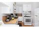 Kitchen area featuring appliances, white cabinetry, and laminate floors at 801 Fugate Ave, Charlotte, NC 28205