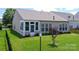 A well-maintained backyard features a lawn and view of the home with a sunroom and patio at 8409 Darcy Hopkins Dr, Charlotte, NC 28277