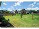 A lush green backyard with a wooden fence and neighboring houses under a bright sky at 8409 Darcy Hopkins Dr, Charlotte, NC 28277