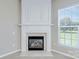 A cozy fireplace with white mantle and marble surround complemented by a window with natural light at 8409 Darcy Hopkins Dr, Charlotte, NC 28277