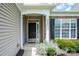 Close-up of the home's front entrance, featuring a black door, stone accents, and landscaped garden at 8409 Darcy Hopkins Dr, Charlotte, NC 28277