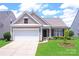 Charming single-Gathering home featuring a two-car garage, manicured lawn, and inviting front porch at 8409 Darcy Hopkins Dr, Charlotte, NC 28277