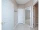 Neutral hallway featuring ceramic tiles, coat hooks, and doorways leading to other rooms at 8409 Darcy Hopkins Dr, Charlotte, NC 28277