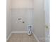 A functional laundry room with tile flooring, shelving, and utility connections at 8409 Darcy Hopkins Dr, Charlotte, NC 28277