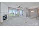 Spacious living room featuring a fireplace, large windows, and a ceiling fan at 8409 Darcy Hopkins Dr, Charlotte, NC 28277