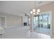 An open-concept living room with a fireplace, chandelier, and sliding doors leading to the outdoors at 8409 Darcy Hopkins Dr, Charlotte, NC 28277