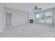 Bright and spacious living room features a fireplace, large windows, and a ceiling fan at 8409 Darcy Hopkins Dr, Charlotte, NC 28277