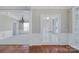 Bright living room featuring elegant chandelier, large windows, and French doors at 8409 Darcy Hopkins Dr, Charlotte, NC 28277