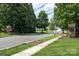 Scenic neighborhood street view with Auburn Place entrance monuments and lush greenery at 8409 Darcy Hopkins Dr, Charlotte, NC 28277