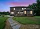 Back exterior view of the home with a wooden deck, stone pathway, and lush green lawn at 9450 Surface Hill Rd, Mint Hill, NC 28227