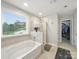 Bathroom with a large soaking tub, separate shower, and a view of the outdoors, offering a spa-like experience at 9450 Surface Hill Rd, Mint Hill, NC 28227