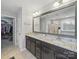 Bathroom showcasing double vanity sinks with granite counters, large mirror, and walk-in closet at 9450 Surface Hill Rd, Mint Hill, NC 28227