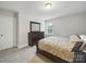 Well-lit bedroom featuring a large dresser, patterned bedding, and plush carpeting at 9450 Surface Hill Rd, Mint Hill, NC 28227