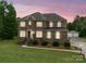 Charming brick two-story home with a well-manicured lawn and traditional architectural details at 9450 Surface Hill Rd, Mint Hill, NC 28227