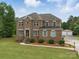 Charming two-story brick home boasts meticulous landscaping, a lush green lawn, and a classic architectural design at 9450 Surface Hill Rd, Mint Hill, NC 28227