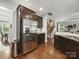Spacious kitchen featuring stainless steel appliances and hardwood floors, leading to the living room and staircase at 9450 Surface Hill Rd, Mint Hill, NC 28227