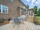 A brick patio features an outdoor dining set and a view of the home's deck and exterior at 9450 Surface Hill Rd, Mint Hill, NC 28227
