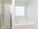Bathroom featuring a glass enclosed shower and a separate tub with a window at 1007 Green Terra Rd, Indian Trail, NC 28079