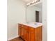 Bathroom with double sink vanity, large mirror, modern lighting, and wood-look flooring at 1007 Green Terra Rd, Indian Trail, NC 28079