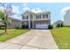 Traditional two-story home featuring a brick facade, attached two-car garage, and a long concrete driveway at 1007 Green Terra Rd, Indian Trail, NC 28079