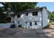 Spacious backyard featuring white brick exterior, ample parking, and mature trees at 1038 Holmes Ave, Salisbury, NC 28144