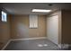 Neutral-toned basement featuring a window, closet, and gray concrete floors at 1038 Holmes Ave, Salisbury, NC 28144