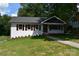 Charming one-story home featuring a well-manicured lawn, crisp white brick, and sidewalk at 1038 Holmes Ave, Salisbury, NC 28144