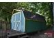 Exterior of a green and blue shed featuring double doors and a black shingle roof at 1038 Holmes Ave, Salisbury, NC 28144