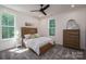 Sunlit bedroom boasts a ceiling fan, plush gray carpet, and a stylish wooden bed at 1062 Sage Pine Cir, Clover, SC 29710