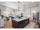 Modern kitchen featuring a large island with seating, stainless steel appliances, and a cozy fireplace at 1062 Sage Pine Cir, Clover, SC 29710