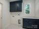 Laundry room features stylish navy blue cabinets, marble countertop, and tiled floors at 1062 Sage Pine Cir, Clover, SC 29710