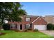 Charming two-story brick home with a well-manicured lawn and attached two-car garage at 11305 Erwin Ridge Ave, Charlotte, NC 28213