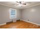 A bedroom with hardwood floors, grey walls and a ceiling fan provides a simple yet cozy space at 1132 Arbor Dr, Salisbury, NC 28144