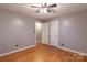 A bedroom with hardwood floors, grey walls and a ceiling fan offers a simple yet cozy space at 1132 Arbor Dr, Salisbury, NC 28144