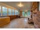 Bright sunroom with ample windows and brick accent wall, ready for your creative touch at 1132 Arbor Dr, Salisbury, NC 28144