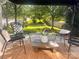 Comfortable back patio featuring four chairs and a stone fire pit in a grassy fenced yard at 115 Morrocroft Ln, Mooresville, NC 28117