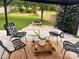 Comfortable back patio featuring four chairs and a stone fire pit in a grassy fenced yard at 115 Morrocroft Ln, Mooresville, NC 28117