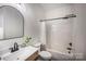Updated bathroom features a modern sink with dark faucet and tiled shower with curtain at 115 Morrocroft Ln, Mooresville, NC 28117