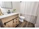 Updated bathroom features a modern sink with dark faucet and tiled shower with curtain at 115 Morrocroft Ln, Mooresville, NC 28117