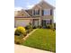 Two-story home with beautiful landscaping, a green lawn, flowers, and stone edging under a clear blue sky at 115 Morrocroft Ln, Mooresville, NC 28117
